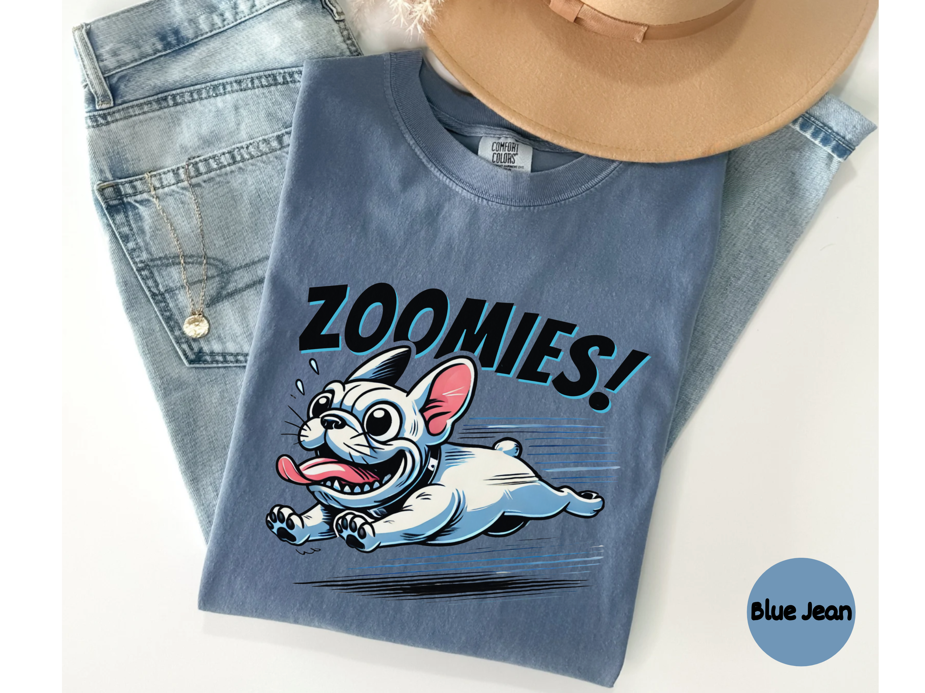 Blue denim t-shirt with cartoon french  bulldog graphic and 'Zoomies!' text, displayed with jeans and a hat