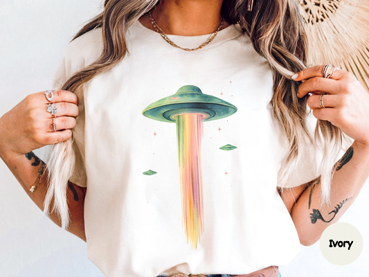 Trippy alien graphic tee showing a flying saucer shooting a multicolor beam of light through space perfect for sci fi lovers and cosmic art fans