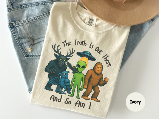 Funny conspiracy humor shirt featuring UFO alien and legendary creatures with bold text reading “The Truth Is Out There And So Am I”