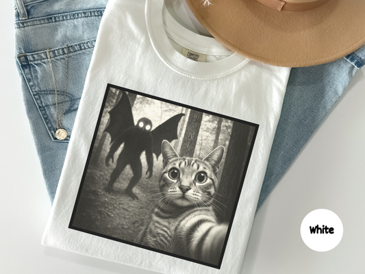 Silly graphic tee showing unbothered cat posing while mothman appears