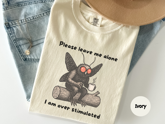 Cute cryptid shirt featuring mothman relaxing with a mug in a cozy forest scene
