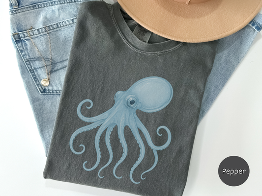 Close up of a black shirt showing a cool glass effect octopus illustration in light blue tones designed for sea life enthusiasts art lovers and shoppers seeking unique aesthetic graphic tees