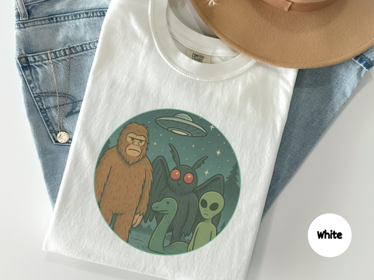 Funny cryptid t shirt featuring Bigfoot Mothman Loch Ness Monster and an alien under a UFO in a forest scene perfect for paranormal fans conspiracy lovers and anyone who enjoys mythical creature art