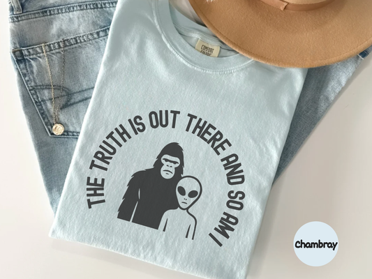 Paranormal graphic tee displaying a clean silhouette of Bigfoot standing beside an alien with a conspiracy slogan ideal for people who enjoy UFO culture cryptids and understated fashion