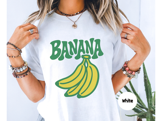 funny banana shirt featuring bold green retro text that says banana above a bright yellow cartoon banana graphic on black background