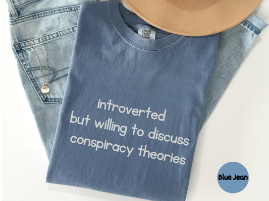 Funny introvert quote shirt displaying the phrase introverted but willing to discuss conspiracy theories in bold white lettering on a black background ideal for quiet thinkers
