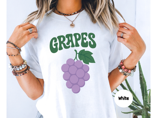 Grapes fruit graphic t shirt featuring a bunch of soft purple grapes with green leaf and retro curved grapes text on black background