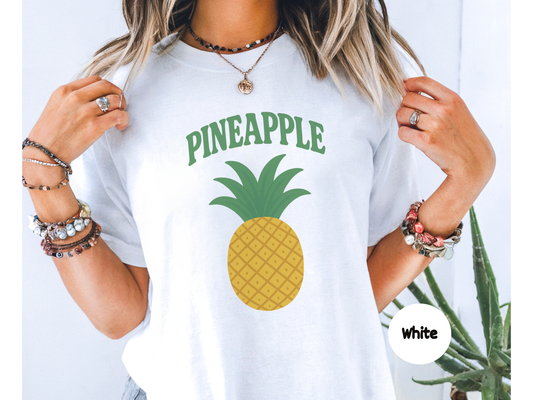Pineapple fruit graphic t shirt featuring a bright yellow pineapple with green leaves and bold retro pineapple lettering on black background
